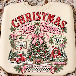 May include: A cream-colored sweatshirt featuring a graphic print with the text CHRISTMAS Tree Farm. The design includes a decorated Christmas tree, a red truck, a red barn, and signs reading FRESH CUT FOR THE SEASON, FARM FRESH TREES, and more.