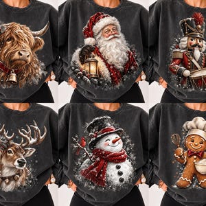 May include: A collection of six charcoal-colored sweatshirts, each featuring a distinct holiday-themed graphic: a Highland cow with a bell, Santa Claus holding a lantern, a nutcracker drummer, a reindeer, a snowman, and a gingerbread baker.