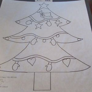 May include: A black and white line drawing of a Christmas tree pattern. The tree is decorated with stars, mittens, and hearts. The text "Burlap Christmas Tree Pattern" is at the bottom. The pattern measures 17 3/4 inches.