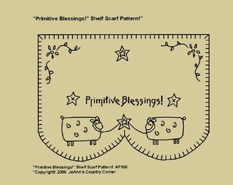May include: A black and white line drawing of a shelf scarf pattern with the text "Primitive Blessings!". The design includes two sheep, stars, and decorative vines. The text "Primitive Blessings!" is centered. The pattern is AP166, copyright 2006.