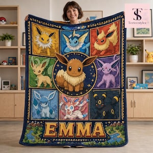 May include: A rectangular fleece blanket featuring a grid of various Eevee evolution characters, with a large central Eevee illustration. The bottom section displays the name EMMA in bold yellow block letters over a landscape graphic design.