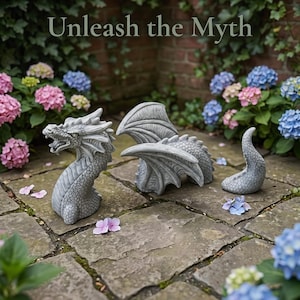 May include: A gray stone-look dragon garden statue in three separate pieces, including a head, a winged body, and a tail, with the text "Unleash the Myth" displayed above. The dragon features detailed scales and textured wings, arranged on a stone patio.