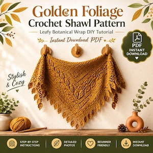Puede incluir: Un chal de ganchillo color amarillo mostaza con un borde de hojas colgado de tres ganchos de madera. El texto dice Golden Foliage Crochet Shawl Pattern, Leafy Botanical Wrap DIY Tutorial, Instant Download PDF, Stylish & Cozy y PDF Instant Download.