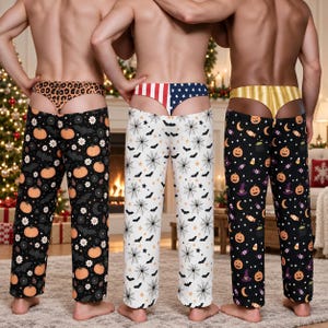 May include: Three pairs of lounge pants with matching thongs. The first pair is black with orange pumpkins and bats. The second is white with black spiderwebs and bats. The third is black with pumpkins, candy, and witch hats. Each has a themed waistband.