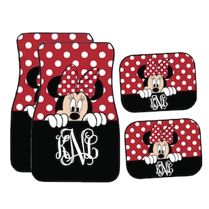 May include: Set of car floor mats featuring Minnie Mouse. The mats have a red and white polka dot pattern with a black base. Minnie Mouse is depicted with her signature bow. The mats also include a white monogram.