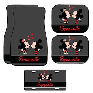May include: A set of car accessories featuring a cartoon couple kissing, with red hearts floating above them. The accessories include two floor mats, two seat covers, and a license plate. The name "Stephanie" is written in red script.