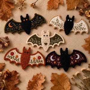Five handmade crochet bat appliqués hanging on a rustic twine garland, cozy autumn decor, warm blurred background
