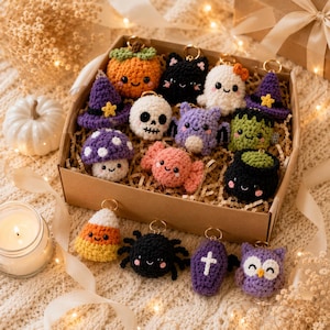 May include: A collection of small, crocheted Halloween-themed keychains featuring various characters including a pumpkin, black cat, ghost, witch hat, skull, bat, Frankenstein monster, mushroom, candy, cauldron, candy corn, spider, coffin, and owl.