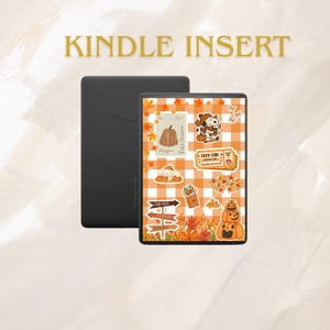 May include: A black e-reader device featuring a decorative insert with an orange and white checkered pattern. The insert displays autumn-themed stickers including pumpkins, fall leaves, a dog character, and text reading KINDLE INSERT.