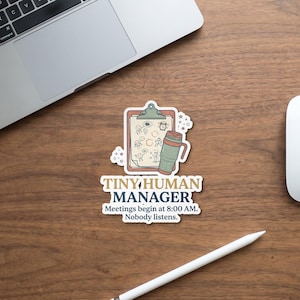 Può includere: Un adesivo fustellato raffigurante una cartellina con disegni di omini stilizzati, una sveglia e una tazza da viaggio. Il testo recita: TINY HUMAN MANAGER. Meetings begin at 8:00 AM. Nobody listens. Il design usa toni tenui di verde, rosso e blu.
