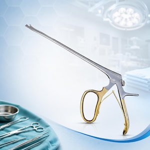 May include: A surgical rongeur instrument featuring a long, slender silver shaft with a notched tip and gold-toned finger ring handles. The tool is constructed from polished metal, showcasing a mechanical hinge mechanism for precise operation.