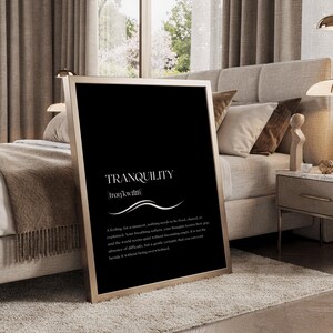 May include: A rectangular framed wall art piece featuring a black background with white text. The word TRANQUILITY is printed in large capital letters, followed by its phonetic pronunciation and a definition paragraph in a serif font.