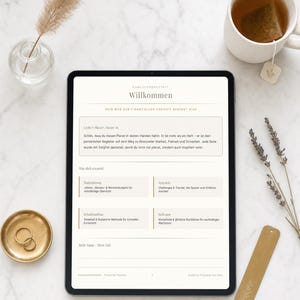 Könnte beinhalten: Ein digitales Tablet mit einer Finanzplaner-Seite, die den deutschen Text Willkommen, Dein Weg zur finanziellen Freiheit beginnt hier sowie Abschnitte für Budgetierung, Sparziele, Schuldenabbau und Reflexion auf einer weißen Oberfläche zeigt.