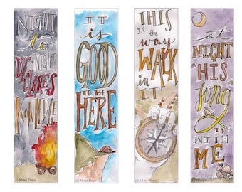 May include: Four watercolour bookmarks with hand-lettered inspirational quotes. The first bookmark features a campfire with the text "Night to Declares Knowledge". The second bookmark features a mountain scene with the text "It is Good to be Here". The third bookmark features a hand holding a compass with the text "This is the way walk in it". The fourth bookmark features a cricket with the text "At night his song is with me".