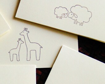 May include: Two black and white line drawings of giraffes on a white background. The giraffes are standing next to each other, with the smaller giraffe's head resting on the larger giraffe's neck.