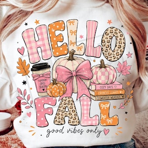 Könnte beinhalten: Ein weißes Sweatshirt mit dem Text HELLO FALL und good vibes only. Das Design zeigt Kürbisse, einen Kaffeebecher mit der Aufschrift PUMPKIN SPICE SEASON und einen Stapel Bücher mit den Titeln COZY DAYS, CRUNCHY LEAVES und SWEATER WEATHER.