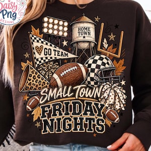Könnte beinhalten: Ein dunkelbraunes Sweatshirt mit einem Grafikdruck, der den Text "SMALL TOWN FRIDAY NIGHTS" und "HOME TOWN" enthält. Das Design zeigt einen Football, einen Helm, ein Megafon, einen Wimpel, einen Wasserturm, Flutlichtmasten und einen Pompon.