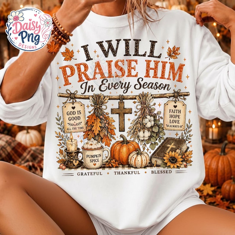 May include: A white long-sleeve sweatshirt featuring a graphic print with the text I WILL PRAISE HIM In Every Season. The design includes a wooden cross, pumpkins, a mug labeled PUMPKIN SPICE, a Bible, and hanging tags with religious text.