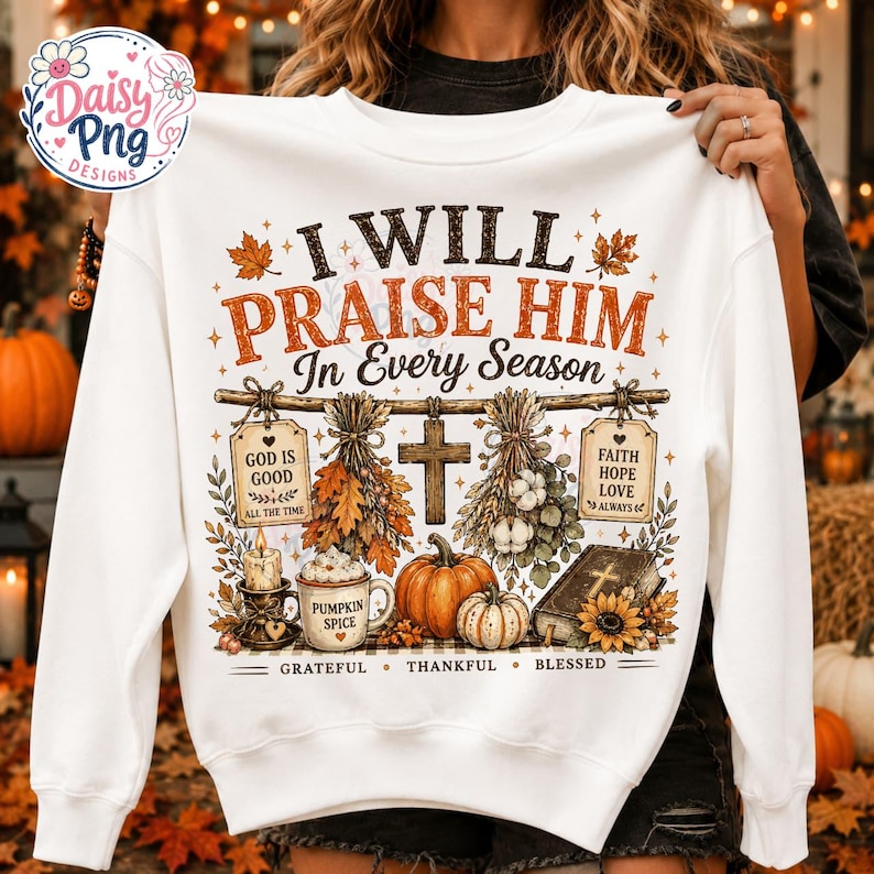 May include: A white long-sleeve sweatshirt featuring a graphic print with the text I WILL PRAISE HIM In Every Season. The design includes a wooden cross, pumpkins, a candle, a mug labeled PUMPKIN SPICE, a Bible, and autumn foliage.