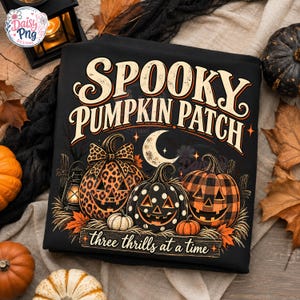 Könnte beinhalten: Ein schwarzes T-Shirt mit dem Text SPOOKY PUMPKIN PATCH und three thrills at a time. Die Grafik zeigt drei Kürbisse mit Leopardenmuster, Punkten und Karomuster, einen Halbmond sowie eine Laterne.
