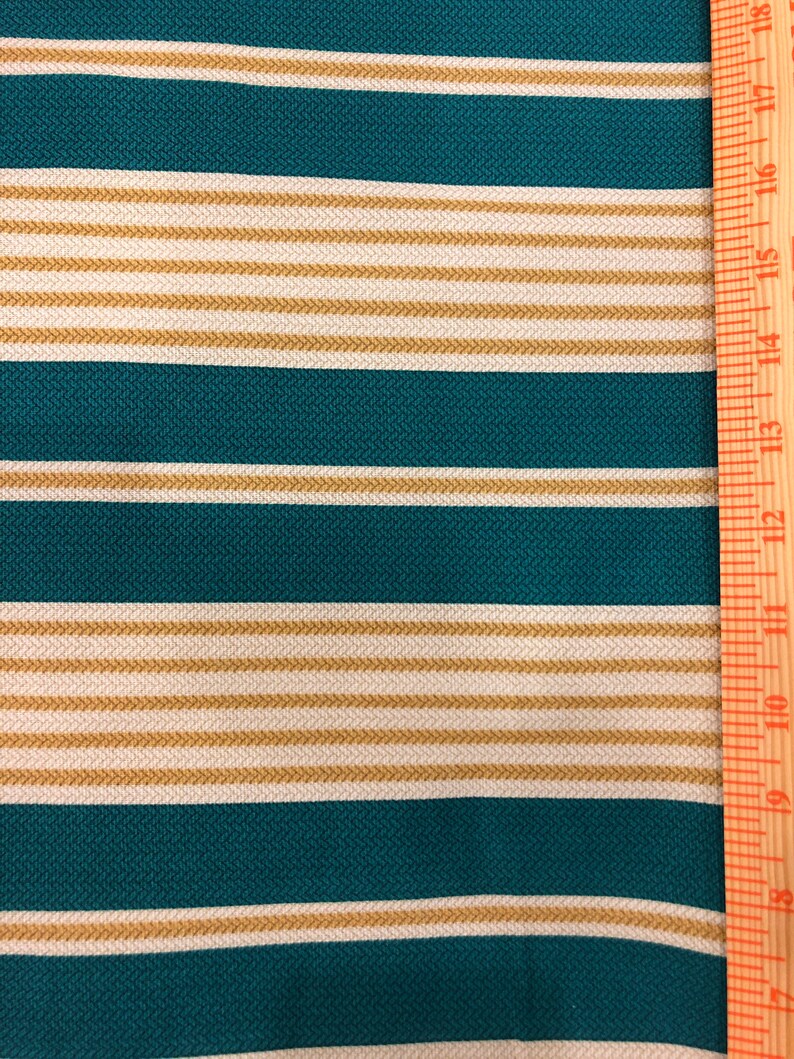 May include: Teal and beige striped fabric with a ruler measuring 18 inches.