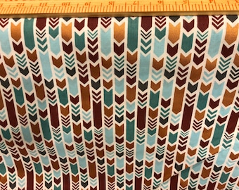 May include: White fabric with a repeating pattern of brown, teal, and gold arrows. The arrows are pointing downwards and are arranged in vertical rows.