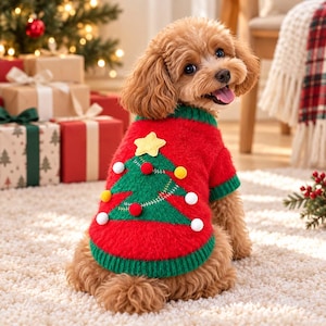 Puede incluir: Un suéter para mascota rojo y verde con un diseño de árbol de Navidad tejido en la espalda, adornado con una estrella amarilla y pequeños pompones blancos, rojos y amarillos. El suéter tiene cuello y dobladillo verde acanalado, usado por un perro marrón pequeño.