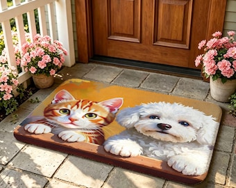 Op de afbeelding: Een rechthoekige deurmat met een bedrukte illustratie van een oranje cyperse kat en een witte pluizige hond die hun voorpoten op een rand laten rusten tegen een effen mosterdgele achtergrond. De mat ligt op een stenen terras.