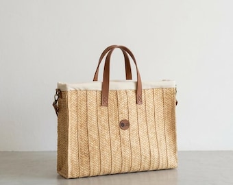 Bolso de fibra natural con asas de piel y correa de piel extraíble.
