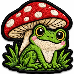 May include: An embroidered patch featuring a bright green frog with large yellow eyes and pink cheeks sitting in green grass under a large red mushroom with white spots. The design has a thick black border outlining the entire shape.