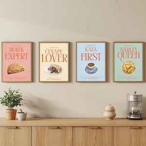 Könnte beinhalten: Vier rechteckige Wandbilder in Holzrahmen. Das rosa Bild zeigt ein Gebäck und den Text BUREK EXPERT. Das cremefarbene Bild zeigt Fleisch und Brot mit ĆEVAPE LOVER. Das blaue Bild zeigt Kaffee mit KAFA FIRST. Das grüne Bild zeigt Essen mit SARMA QUEEN.