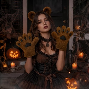 May include: A brown faux fur bear ear headband and matching brown faux fur paw gloves with black paw pads. The gloves feature five fingers with black circular pads on each fingertip and a larger central black pad on the palm of each hand.