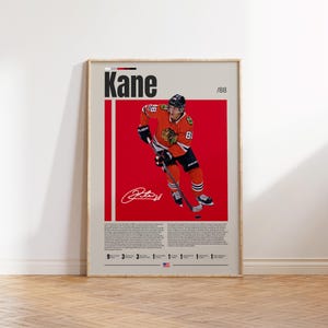 Op de afbeelding: Een verticale poster met een ijshockeyspeler in een rood, zwart en wit shirt met nummer 88, die een hockeystick vasthoudt. De tekst Kane en /88 staat bovenaan, met een witte handtekening onder de speler en gedetailleerde tekst onderaan.