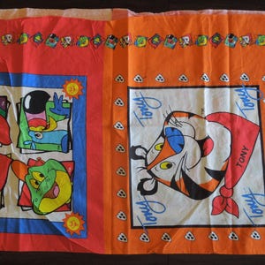 May include: A rectangular fabric panel featuring a vibrant print of Tony the Tiger and other cartoon characters. The left side displays a grid of four characters, while the right side features a large illustration of Tony the Tiger with the text Tony.