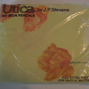 May include: A packaged full fitted sheet by Utica, featuring a yellow background with orange floral designs. The package reads "NO IRON PERCALE" and is designed for a 54x75 in. mattress.