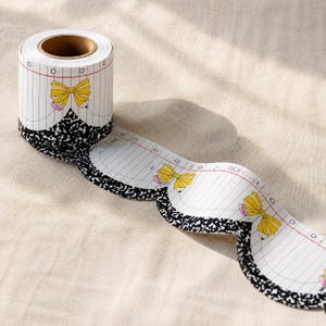 Può includere: Un rotolo di bordo smerlato per bacheche con un motivo a carta bianca a righe, un design a quaderno di composizione maculato bianco e nero sul bordo inferiore e illustrazioni di fiocchi a matita gialla ripetute lungo la lunghezza.