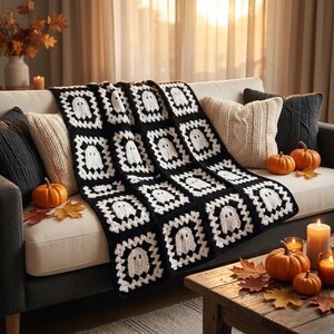 May include: A handmade crochet blanket featuring a repeating pattern of white ghost motifs centered within black square frames. The blanket is constructed from multiple joined granny squares, creating a textured, monochromatic design with a distinct spooky theme.
