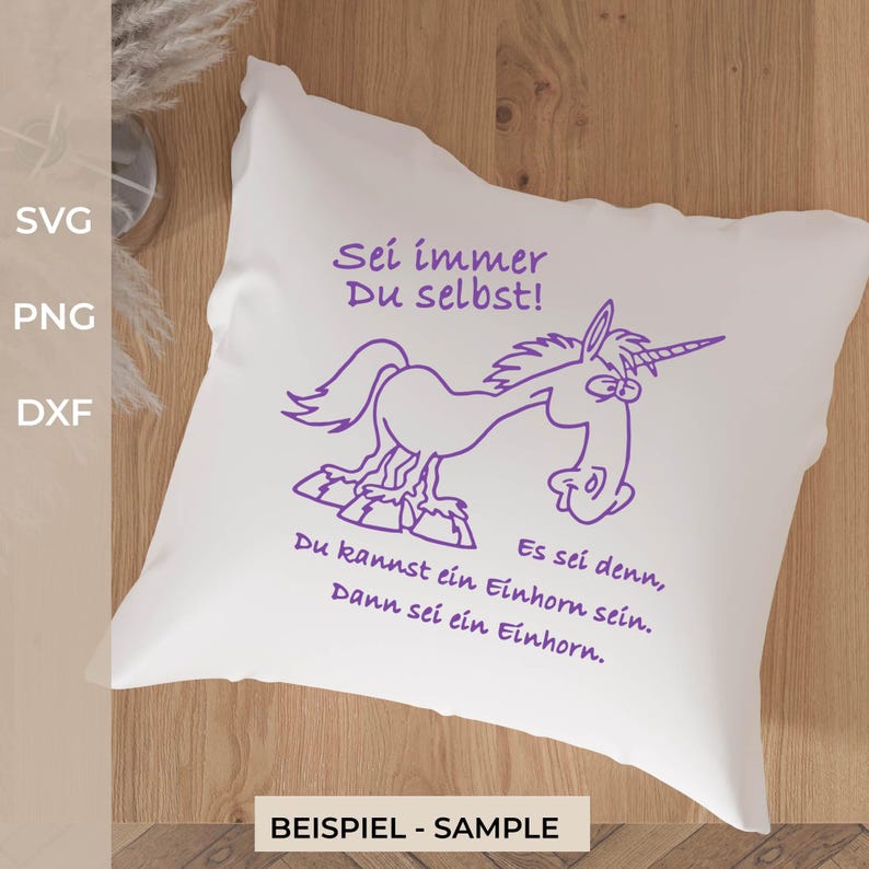 Puede incluir: Un coj&iacute;n cuadrado blanco con un dibujo lineal morado de un unicornio de dibujos animados sobre unas rocas. El texto dice: Sei immer Du selbst! Es sei denn, Du kannst ein Einhorn sein. Dann sei ein Einhorn. El dise&ntilde;o est&aacute; centrado en el coj&iacute;n.
