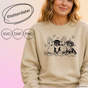 May include: A beige crewneck sweatshirt featuring a black line art graphic of four dachshunds wearing winter hats and scarves, accompanied by pumpkins and autumn leaves. The text "Plotterdatei", "SVG", "DXF", and "PNG" is visible.