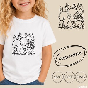 May include: A white t-shirt featuring a black line art graphic of a squirrel holding an acorn surrounded by falling leaves. The image also displays the text Plotterdatei and the file formats SVG, DXF, and PNG in circular outlines.