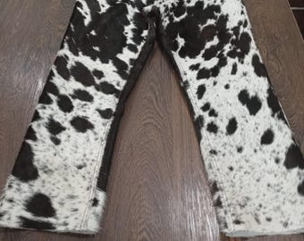 Calça jeans de couro e denim com estampa de vaca em preto e branco, estilo western streetwear (moda anos 2000)
