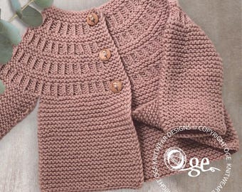 Op de afbeelding: Een stoffige roze gebreide cardigan met houten knopen. De cardigan heeft een eenvoudig steekpatroon en is perfect voor een baby of peuter.