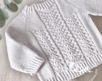 May include: A white knitted jumper with a cable knit pattern. The jumper has a crew neck and long sleeves.