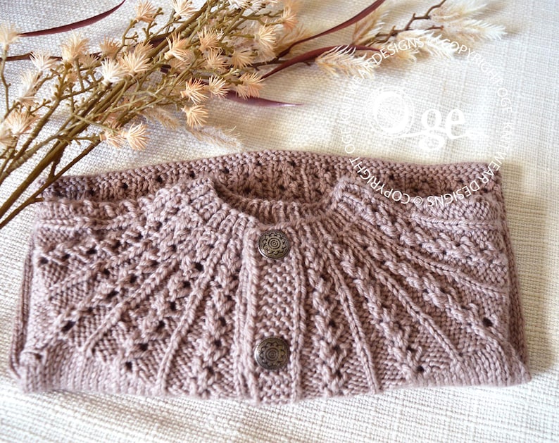 May include: A mauve knitted cardigan with a button closure and a delicate lace pattern. The cardigan is folded in half and laid on a white surface.