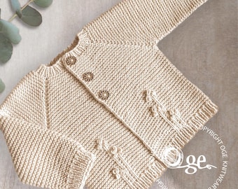 Op de afbeelding: Een beige gebreide baby-cardigan met knoopsluiting en decoratieve stiksels aan de voorkant. De cardigan is gemaakt van zacht garen en heeft een klassiek ontwerp.