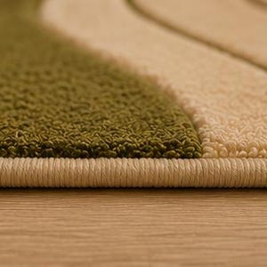 May include: A textured rug featuring alternating wavy bands of olive green and cream. The edge of the rug is finished with a tightly bound cream-colored yarn border that runs horizontally across the bottom of the frame.