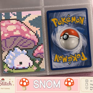 May include: A cross-stitch pattern card featuring a pixelated light blue Snom character under a large pink mushroom, placed next to a standard Pokémon trading card in a clear plastic binder sleeve, with text reading ShinyStitch and SNOM.