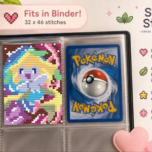 Puede incluir: Una carpeta negra que contiene un patrón de punto de cruz de un personaje amarillo y azul junto a una carta coleccionable Pokemon. El texto dice Fits in Binder! 32 x 46 stitches y Shiny Stitch Cross Stitch Patterns.