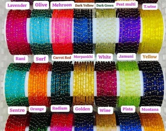 May include: A collection of thin, circular bangles arranged in rows, each featuring a textured surface with small gold-colored flecks. The bangles are displayed in various colors including lavender, olive, red, yellow, green, blue, and pink.