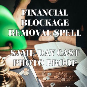 Op de afbeelding: Een persoon zit aan een houten bureau met verspreide koperkleurige munten, een notitieboek en een koperen lamp. De tekst luidt: FINANCIAL BLOCKAGE REMOVAL SPELL SAME DAY CAST PHOTO PROOF. De sc&egrave;ne is donker met een groene lampenkap links.
